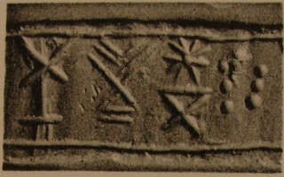 Stamp-cylinder seal: Incense burner and offering table next to divine symbols (cylinder image) – two sitting human-headed winged lions (sphinxes, lamassus), facing each other (stamp image)